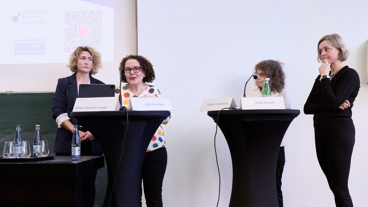 Personen auf einem Podium.