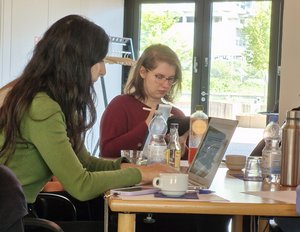 Zwei Personen sitzen an einem Tisch und arbeiten