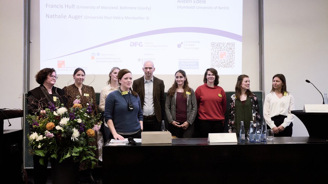 Personen auf einem Podium.