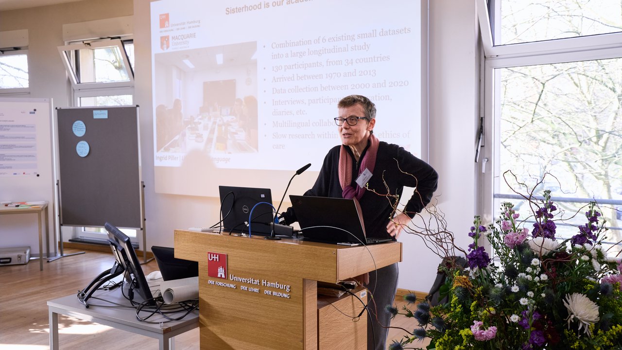 Person am Rednerpult vor einer Präsentation. 
