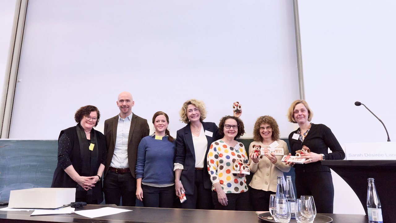 Personen auf einem Podium.