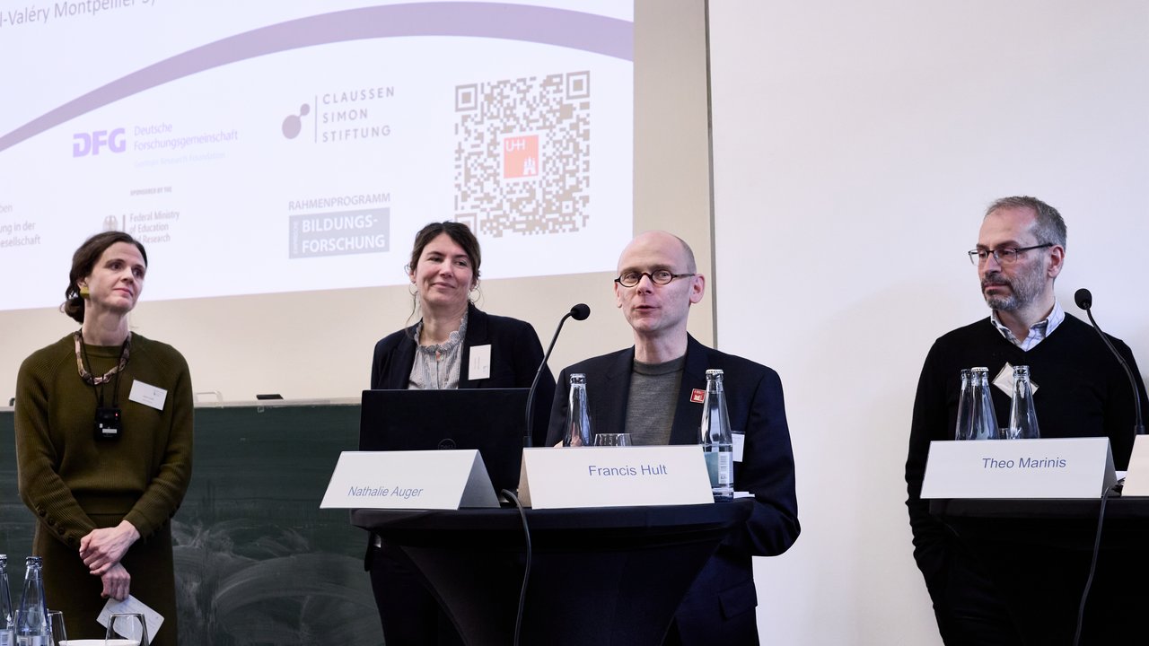 Personen auf einem Podium.