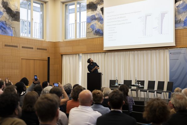 Saal mit Vortragendem und Zuhörenden